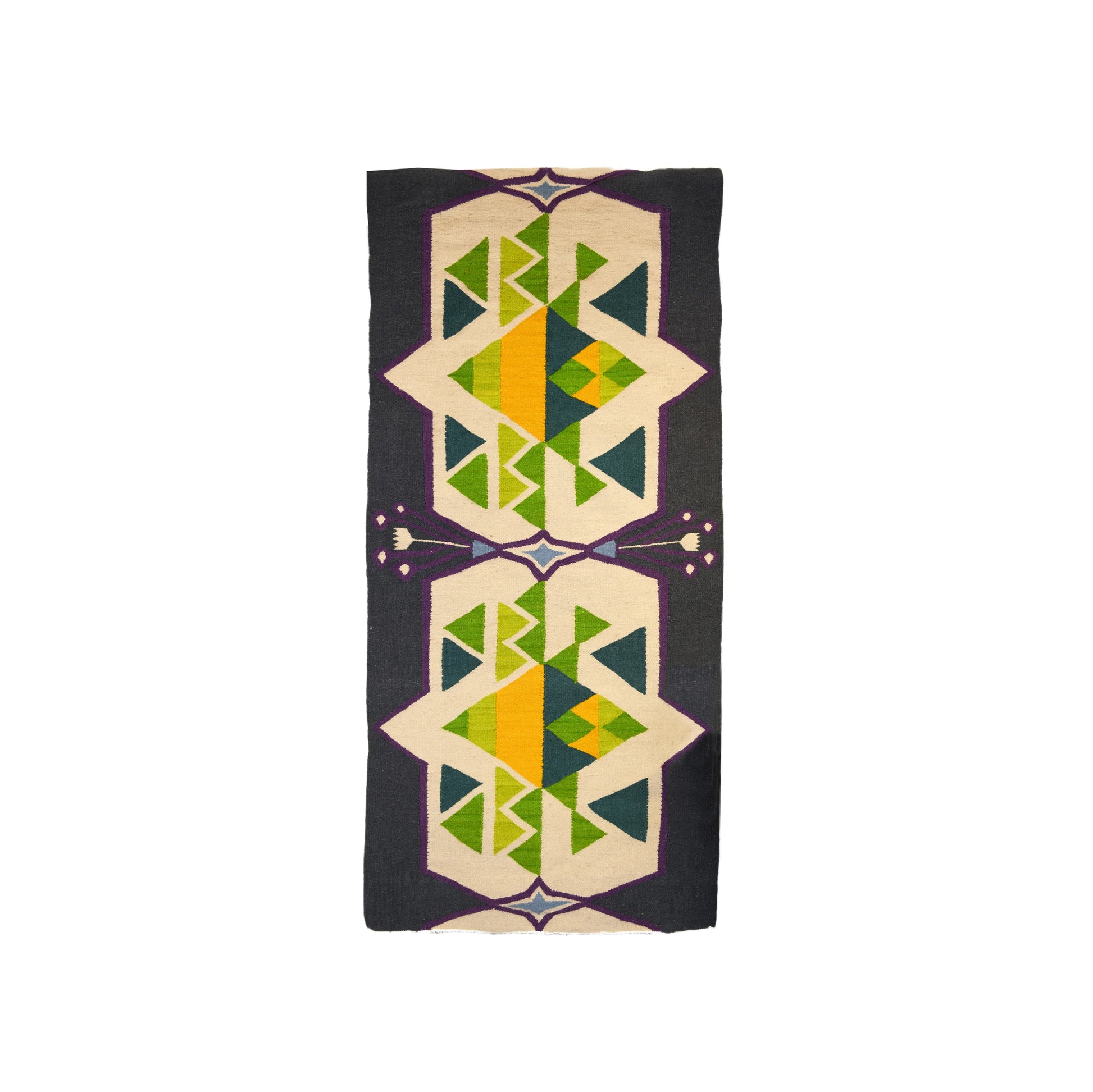 "A woven rug with geometric patterns in green, yellow, blue, and purple on a dark background, displayed vertically."