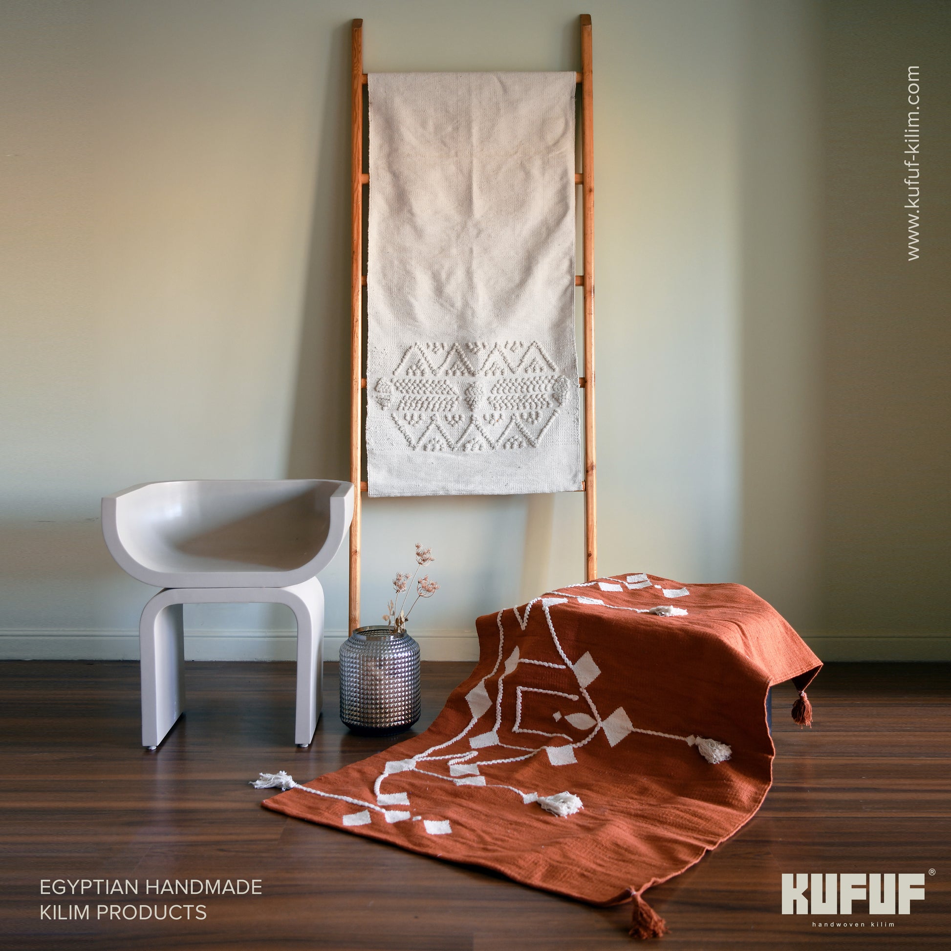 A long, narrow rug (0.7 x 1.5 meters) in a light brownish-tan color. The rug has a slightly textured, woven appearance with subtle variations in shade. A band of white geometric designs, including triangles, zigzags, and stylized arrow shapes, is woven into the lower third of the rug. The overall style is simple yet elegant.